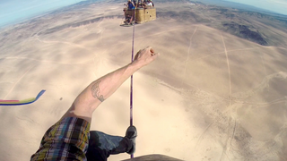 The terrifying view of a slackline walker between hot air balloons